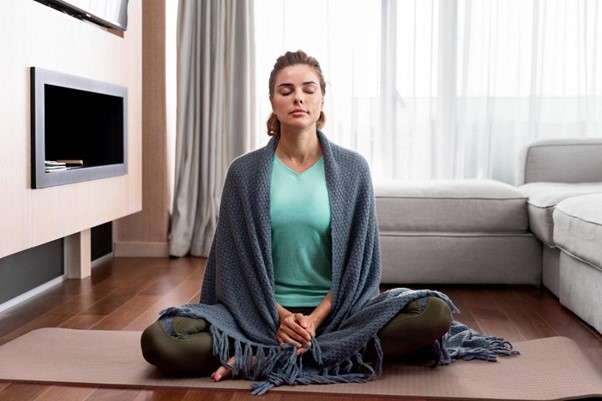 women sat on floor meditating